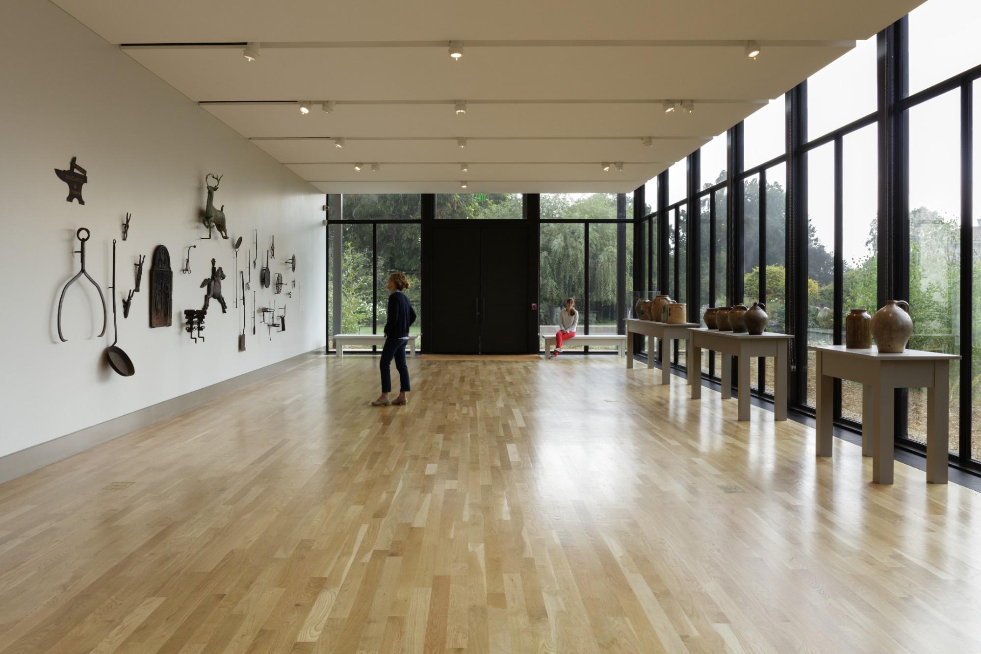 art gallery with one glass wall and one wall covered with iron pieces