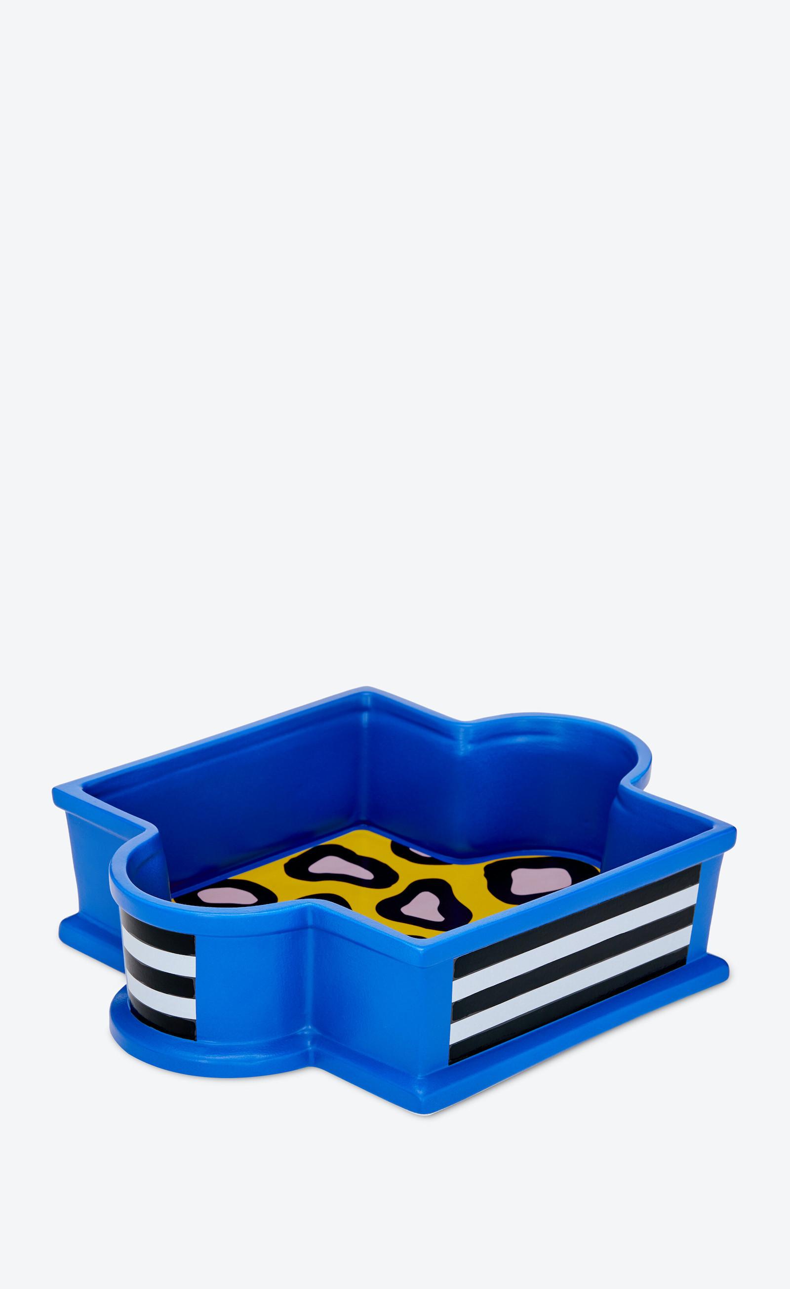 square-shaped tray in royal blue, with two semi-circles to hold. Black and white stripes adorn the sides on parts of the tray. On the interior, it has a yellow, pink, and black leopard print surface.