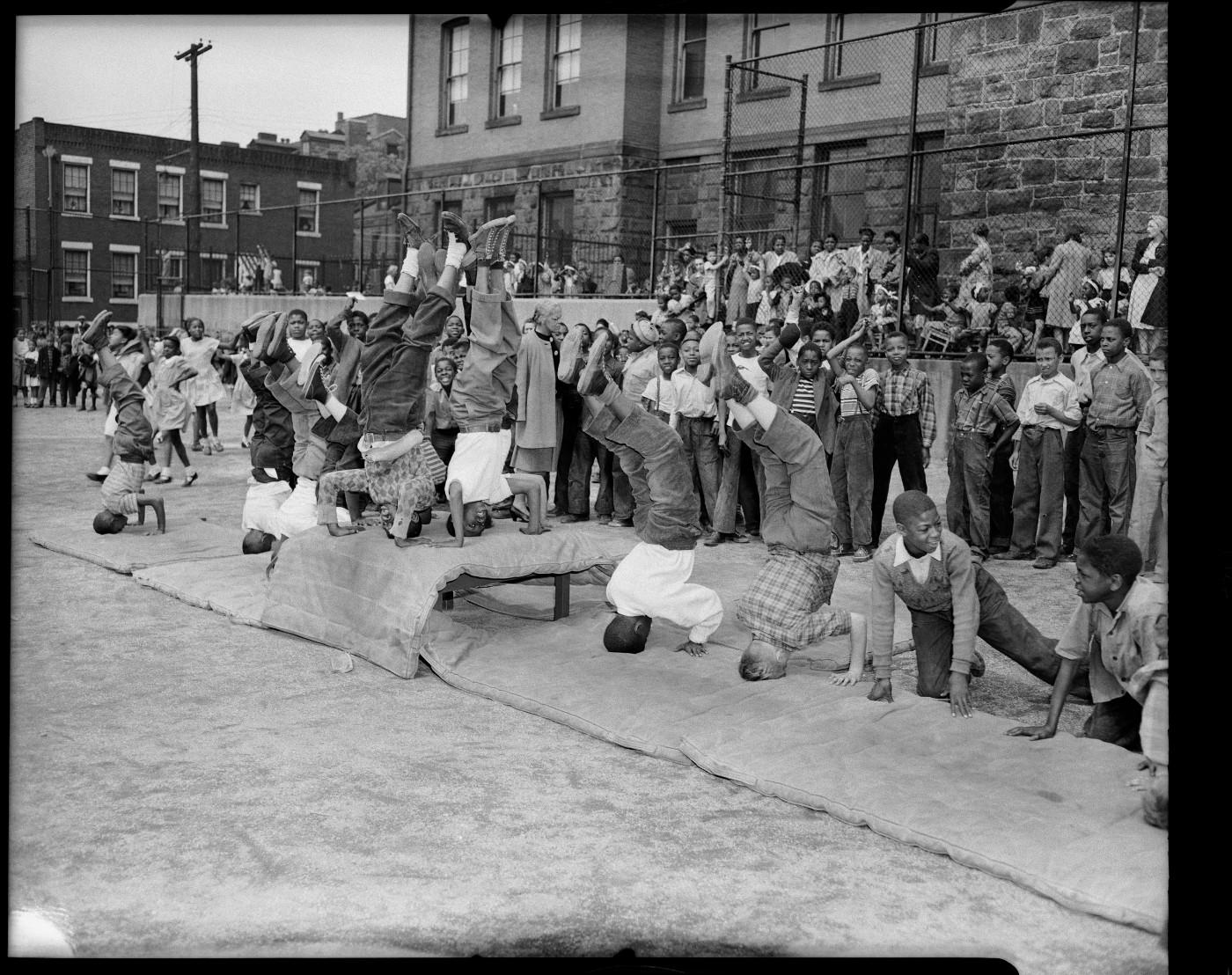 Charles “Teenie” Harris, ‘School boys doing headstands on mats in school yard,’ c. 1955