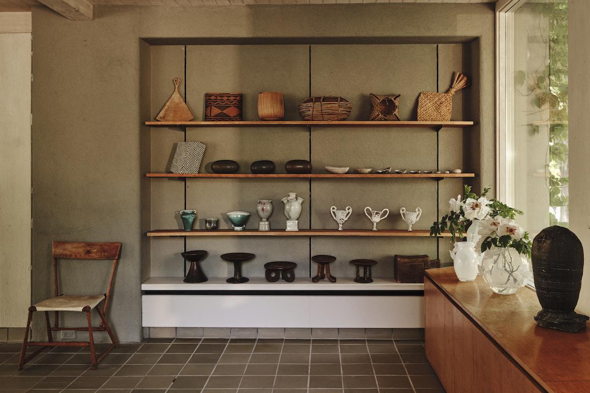 A Summer Arrangement: Object &amp; Thing at LongHouse. LongHouse, East Hampton, New York. Photo by Adrian Gaut. Works pictured: [far left] Wharton Esherick chair from the collection of LongHouse; [shelves]; an arrangement of baskets, seed pods, shells and wooden stands from the collection of LongHouse alongside ceramics by Cody Hoyt, Frances Palmer and Raina Lee; [console]; Sophie Lou Jacobsen, Giardino Vase I, II and III (2023); Adam Silverman, Untitled (2019–19).
