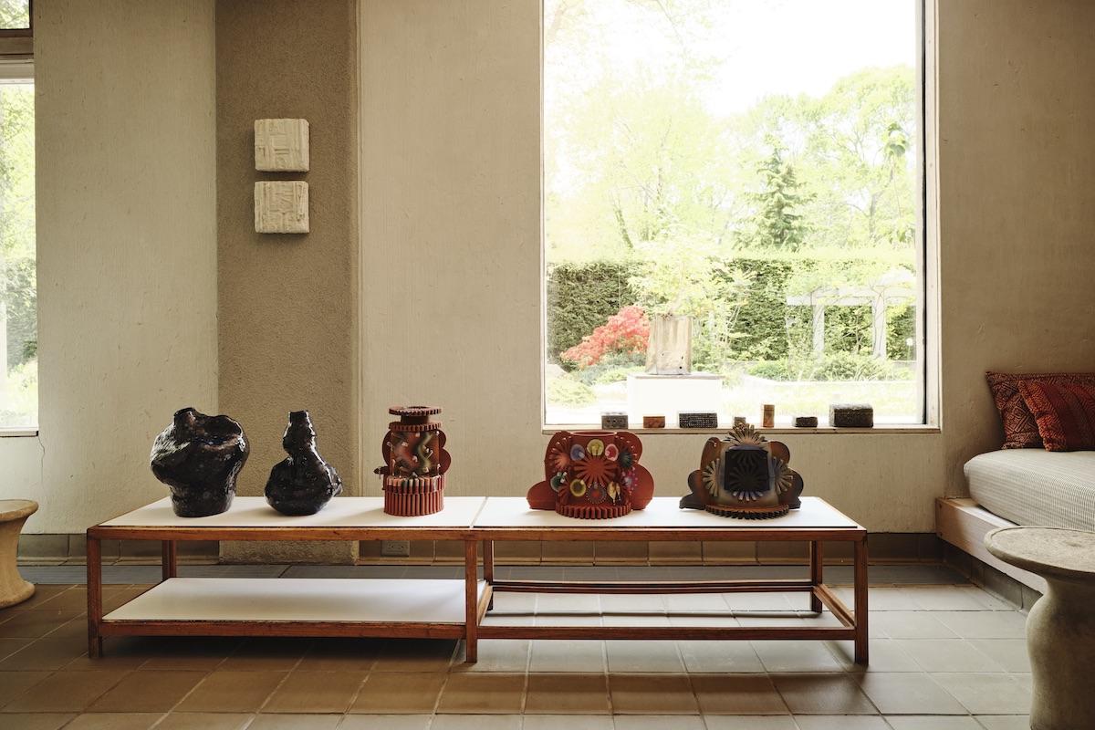 A Summer Arrangement: Object &amp; Thing at LongHouse. LongHouse, East Hampton, New York. Photo by Adrian Gaut. Works pictured: [on wall] Simone Bodmer-Turner, House Painting, Woven Cattails (2023) and House Painting, Woven Lilies (2022–23); [on table] ceramics by Julia Chiang and Jolie Ngo.