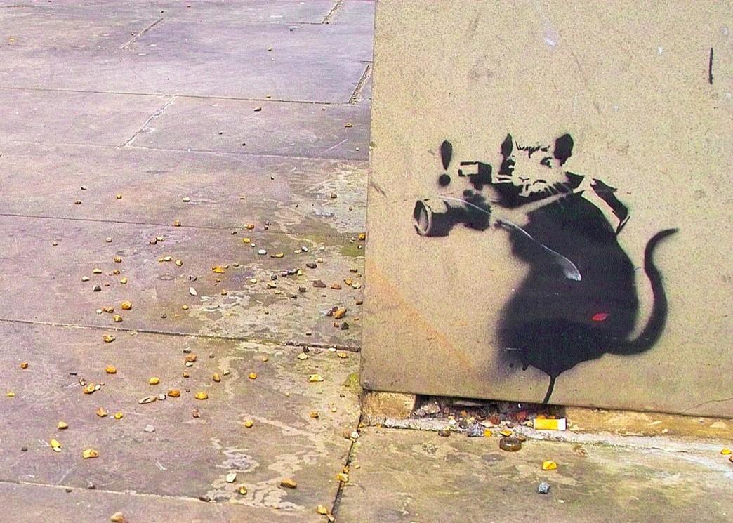 Banksy rat graffiti with small rat dressed as paparazzi