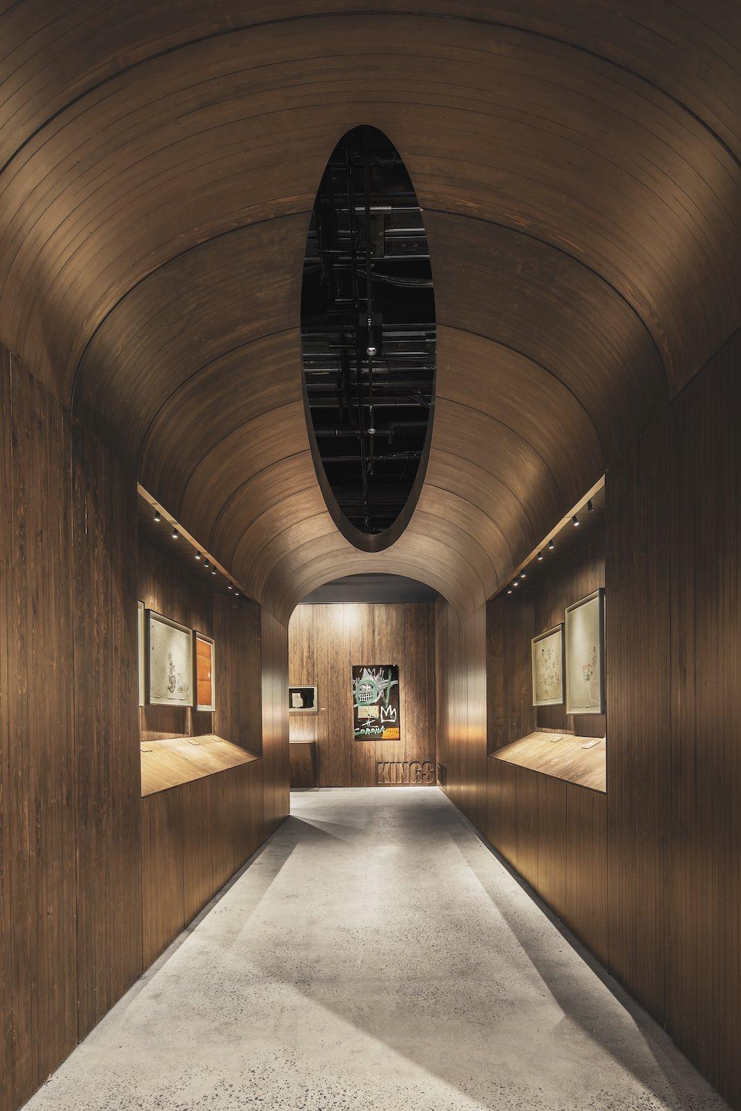Interior view of Jean-Michel Basquiat- King Pleasure. Photo by Ivane Katamashvili featuring the wood-pannel-esq architectural framework of the show provided by Sir David Adjaye.